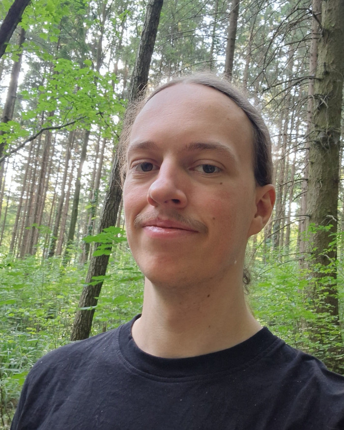 Porträt von Sam vor einem Waldhintergrund